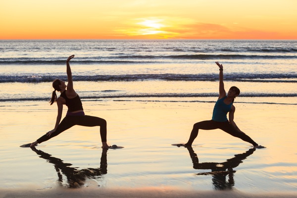 Women practicing Yoga reflected in wet sand on Pacific Beach at sunset, San Diego, California, USA © Stuart Westmorland/evolveimages.com